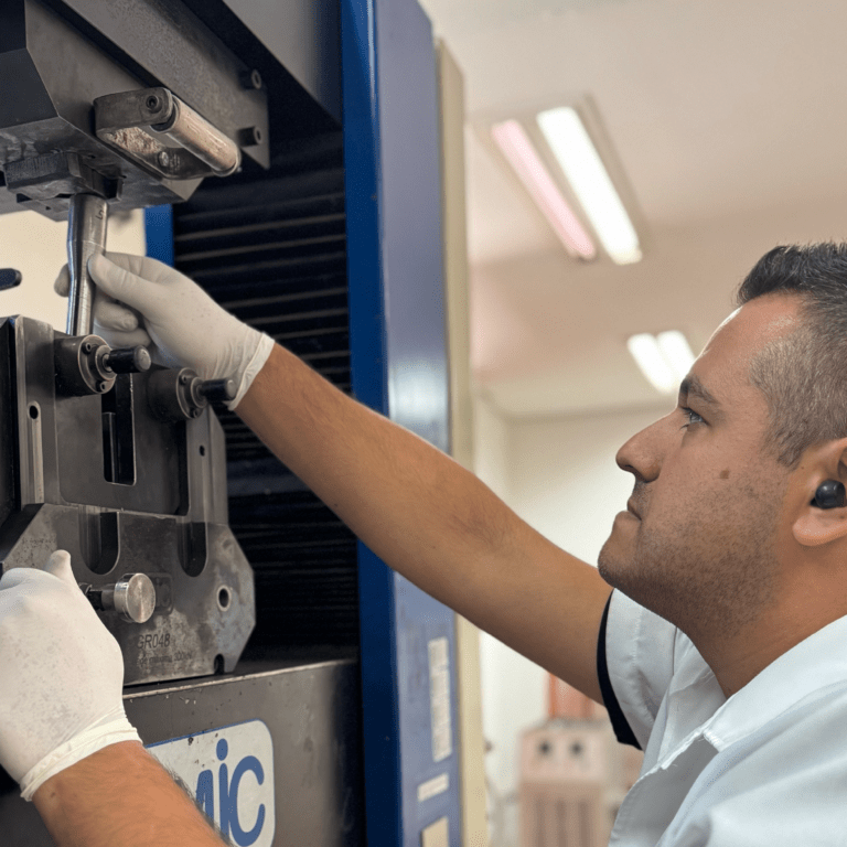 técnico inserindo corpo de prova em equipamento de ensaio de tração